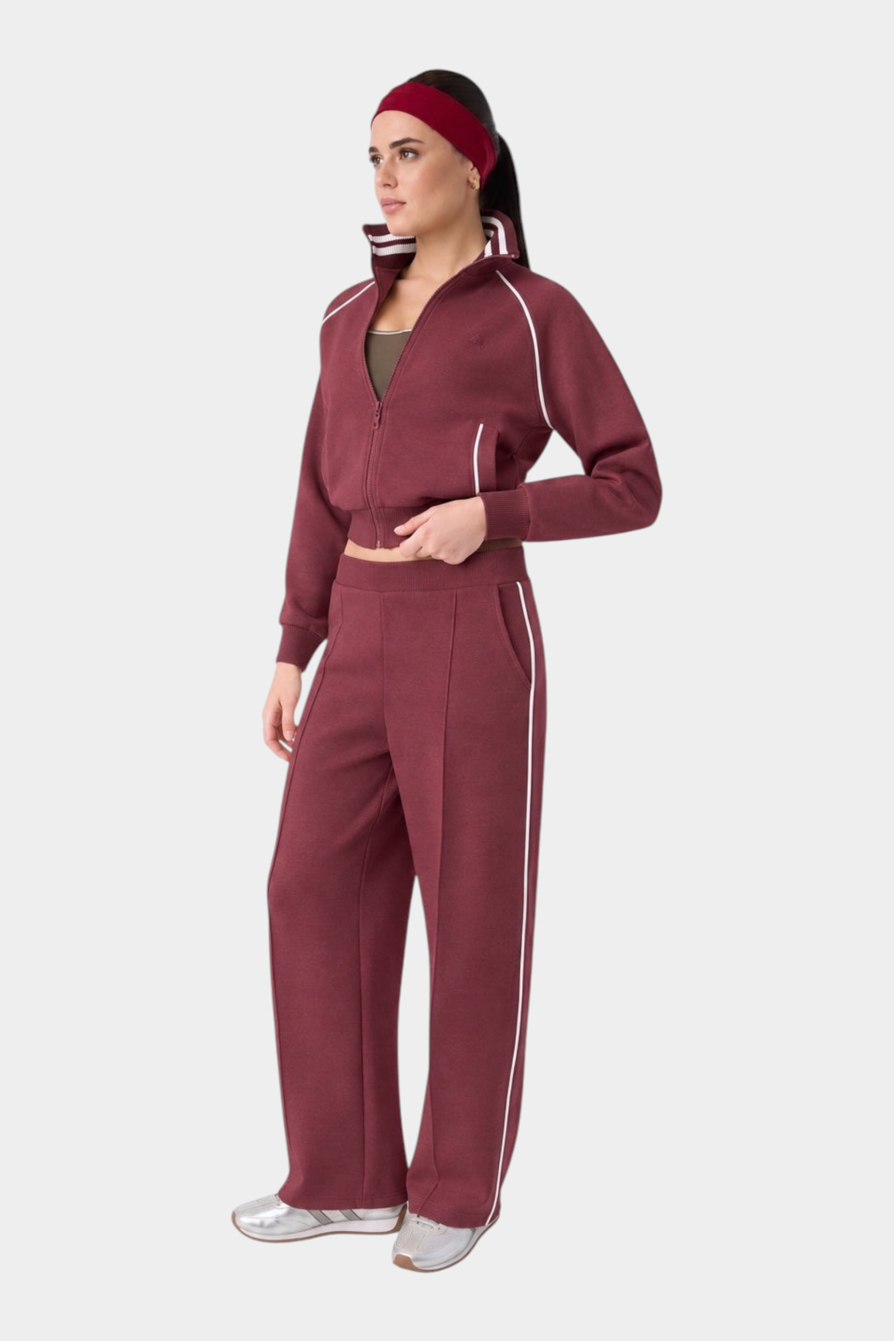 Modella indossa tuta sportiva bordeaux Follower SRL con felpa full zip e pantaloni a gamba larga con righe bianche