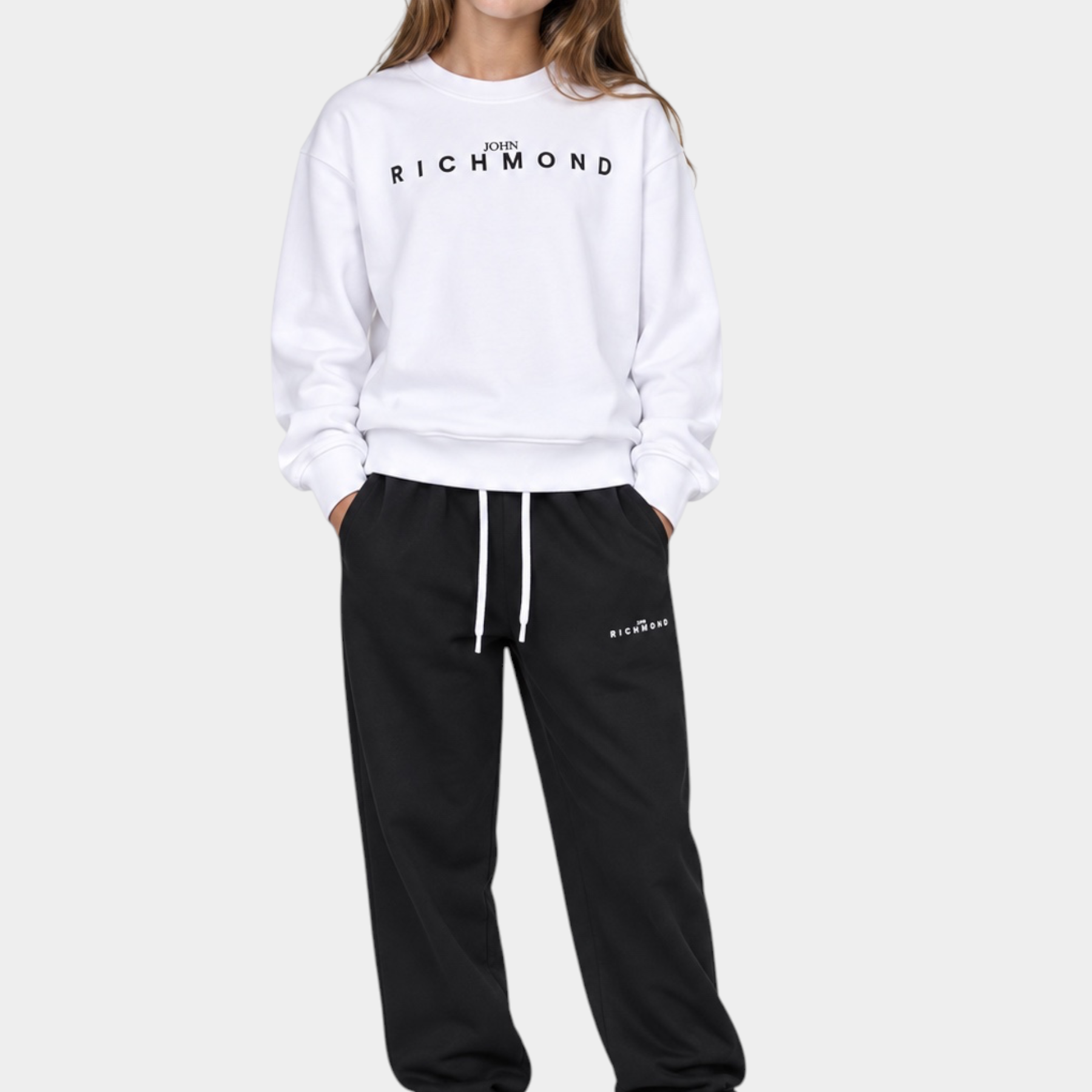 Ragazza indossa completo sportivo Follower SRL con felpa bianca e pantaloni neri con logo John Richmond