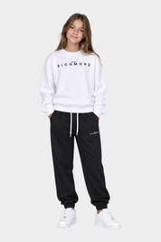 Ragazza indossa completo sportivo Follower SRL con felpa bianca e pantaloni neri con logo John Richmond