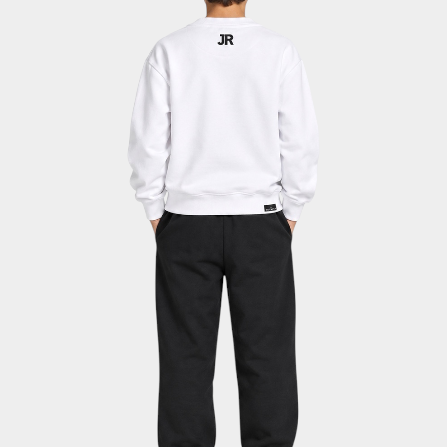 Ragazzo indossa completo sportivo Follower SRL con felpa bianca e pantaloni neri, vista posteriore