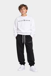 Ragazzo indossa completo sportivo Follower SRL con felpa bianca e pantaloni neri con logo Richmond