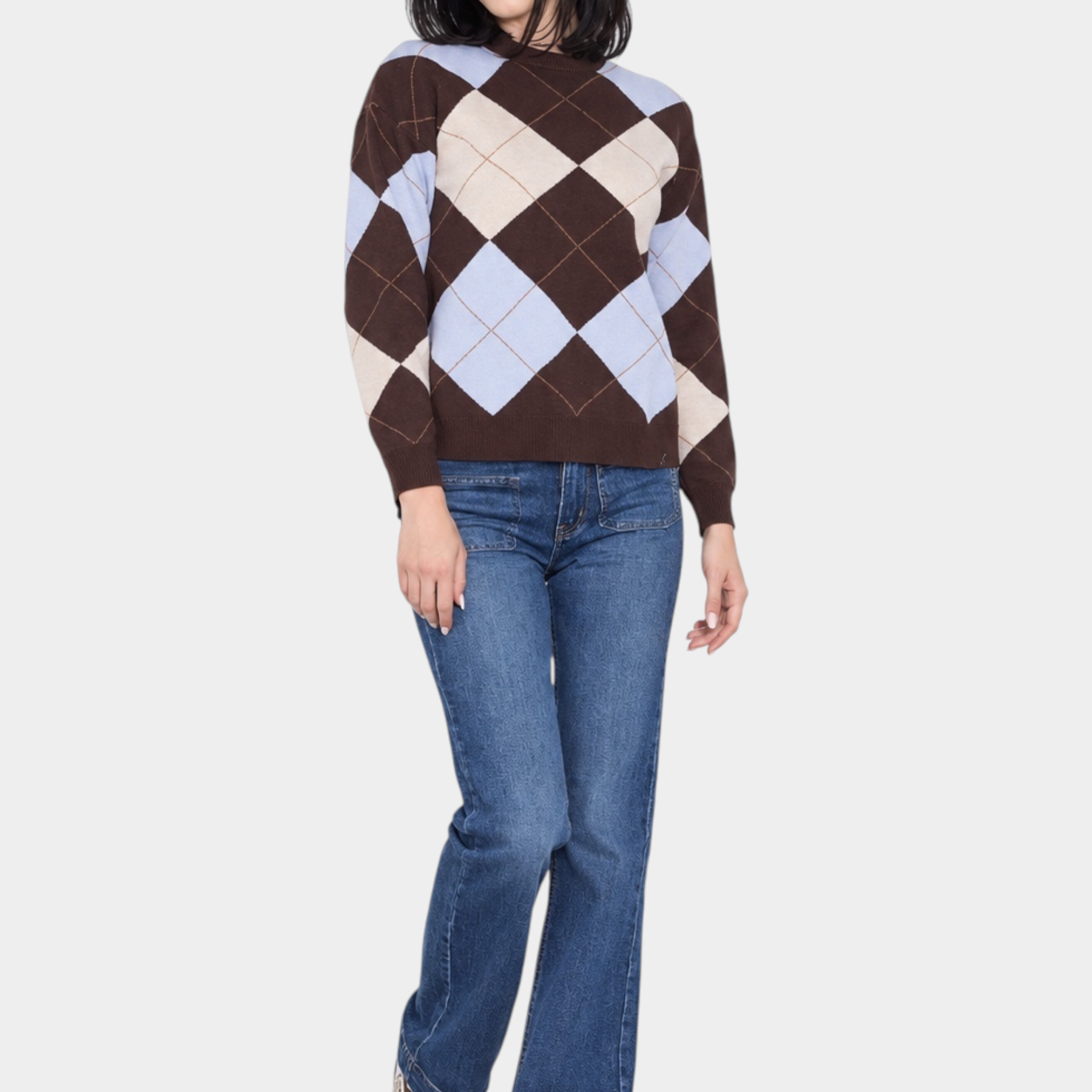 Modella indossa un maglione Follower SRL a rombi marroni e azzurri con jeans blu e sneakers