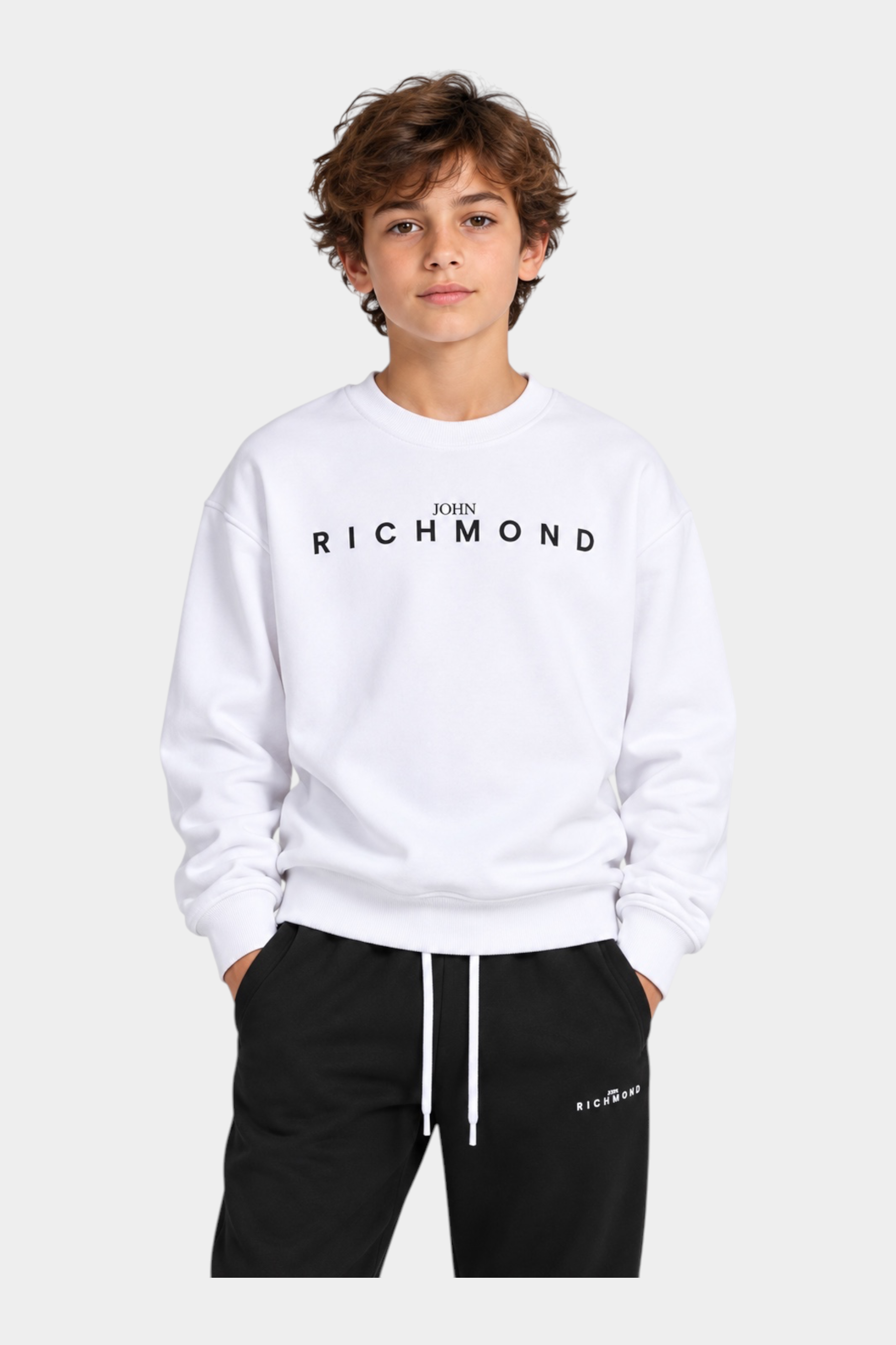Completo sportivo Follower SRL bianco e nero con felpa girocollo e logo John Richmond indossato da un ragazzo