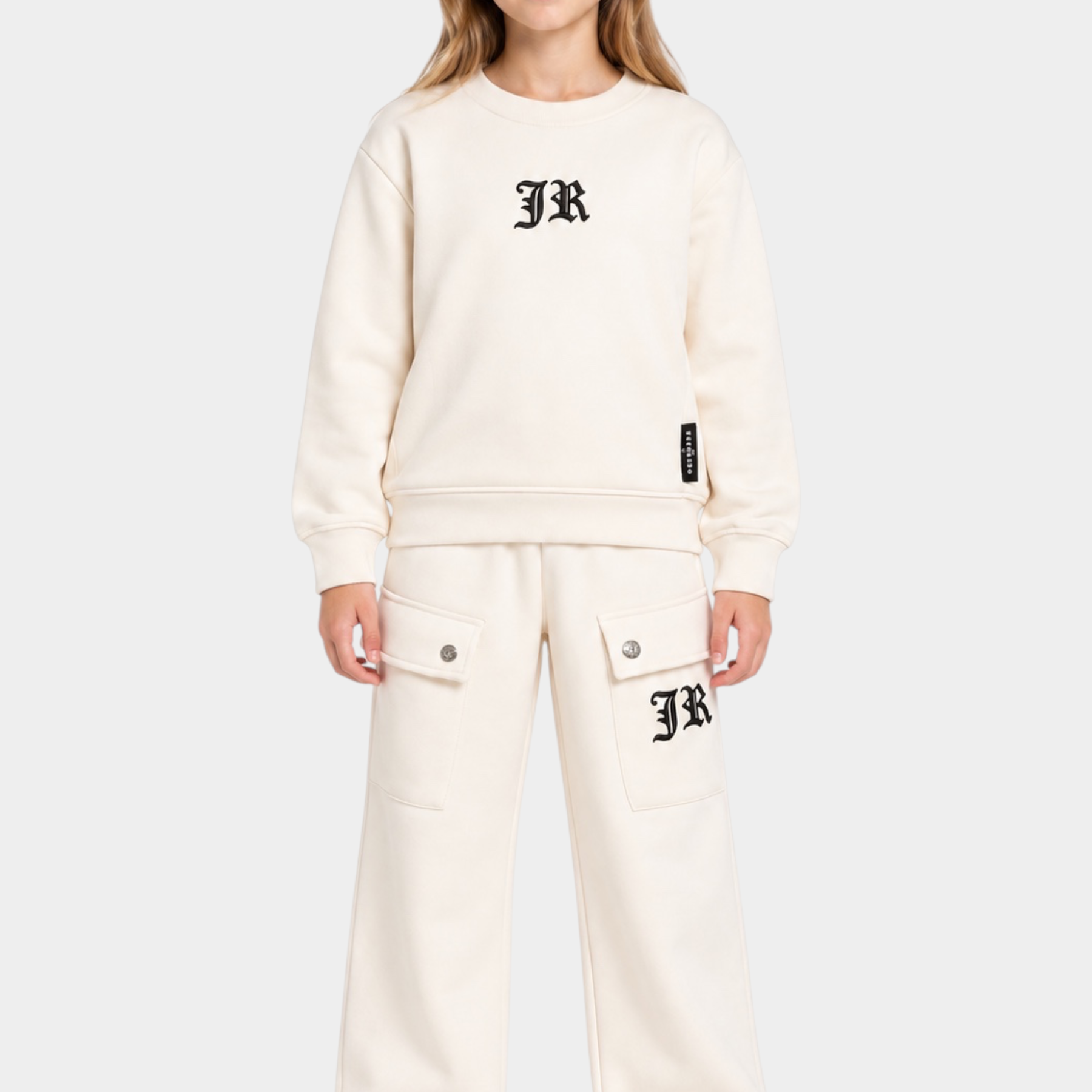 Ragazza indossa un completo sportivo Follower SRL beige con felpa girocollo e pantaloni cargo con logo JR nero