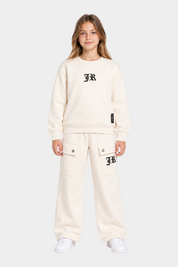Ragazza indossa un completo sportivo Follower SRL beige con felpa girocollo e pantaloni cargo con logo JR nero