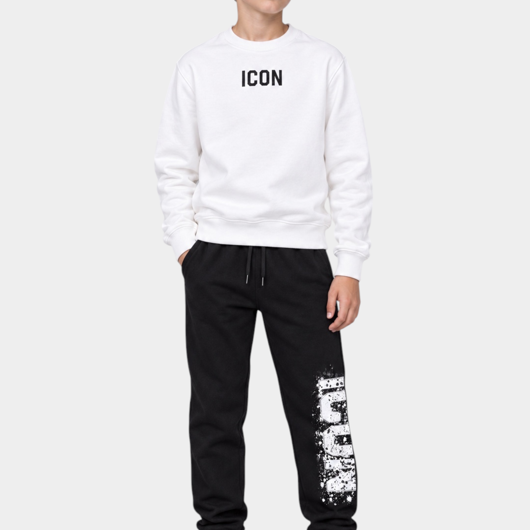Ragazzo indossa pantaloni jogger neri ICON di Follower Official con felpa bianca abbinata e scarpe da ginnastica