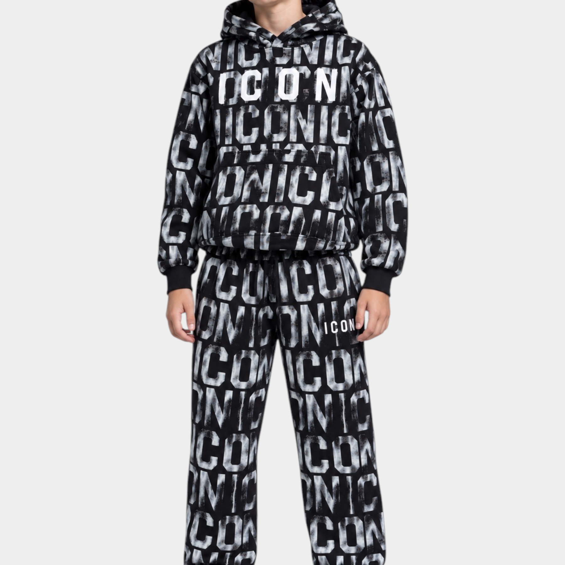 Ragazzo indossa una tuta Follower Official nera con stampa ICON bianca all-over, felpa con cappuccio e pantaloni jogger