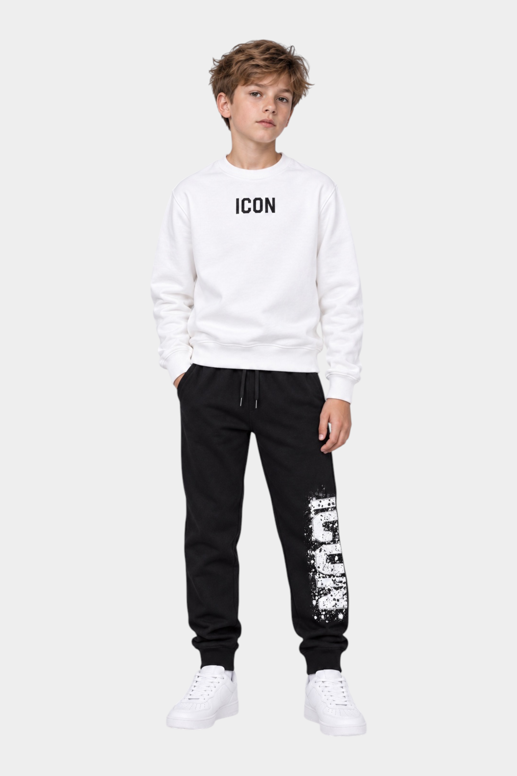 Ragazzo indossa felpa bianca Follower Official girocollo con scritta ICON e pantaloni neri con stampa effetto spray