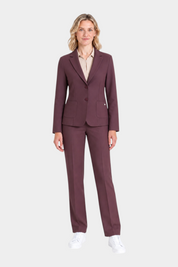 Modella indossa un blazer bordeaux a due bottoni Follower SRL con pantaloni coordinati e scarpe da ginnastica bianche