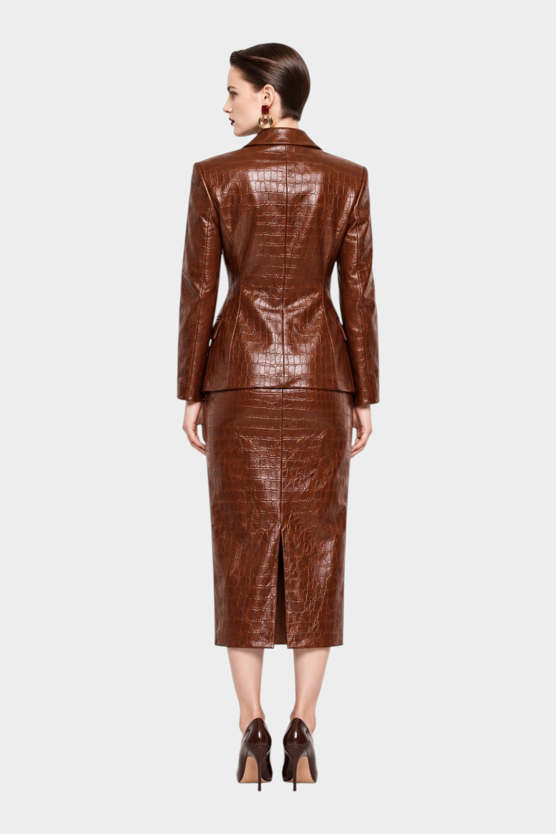 Modella di spalle indossa blazer e gonna midi in similpelle marrone effetto coccodrillo di Follower SRL