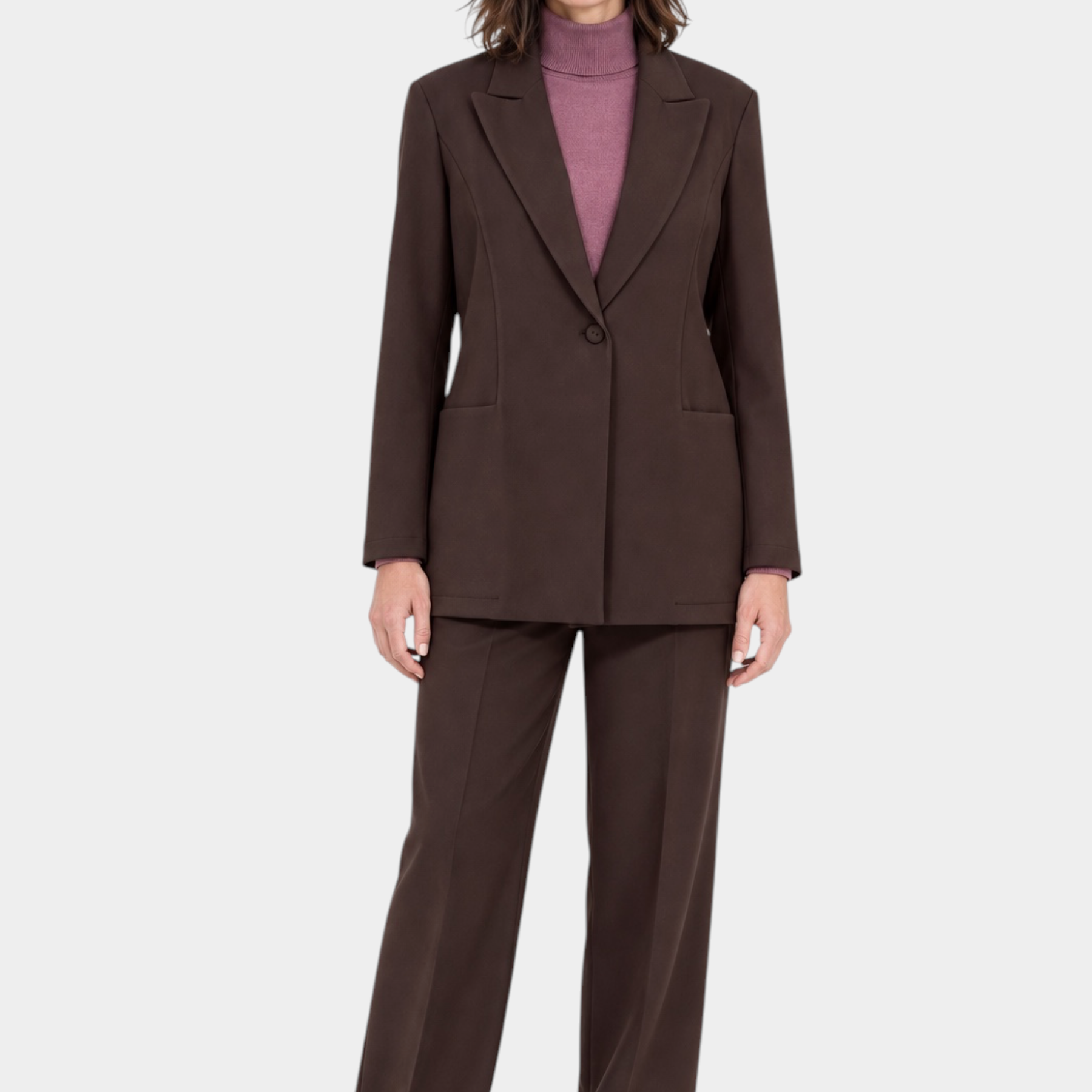 Modella indossa blazer marrone Follower SRL con rever a lancia, abbinato a pantaloni coordinati e maglia rosa