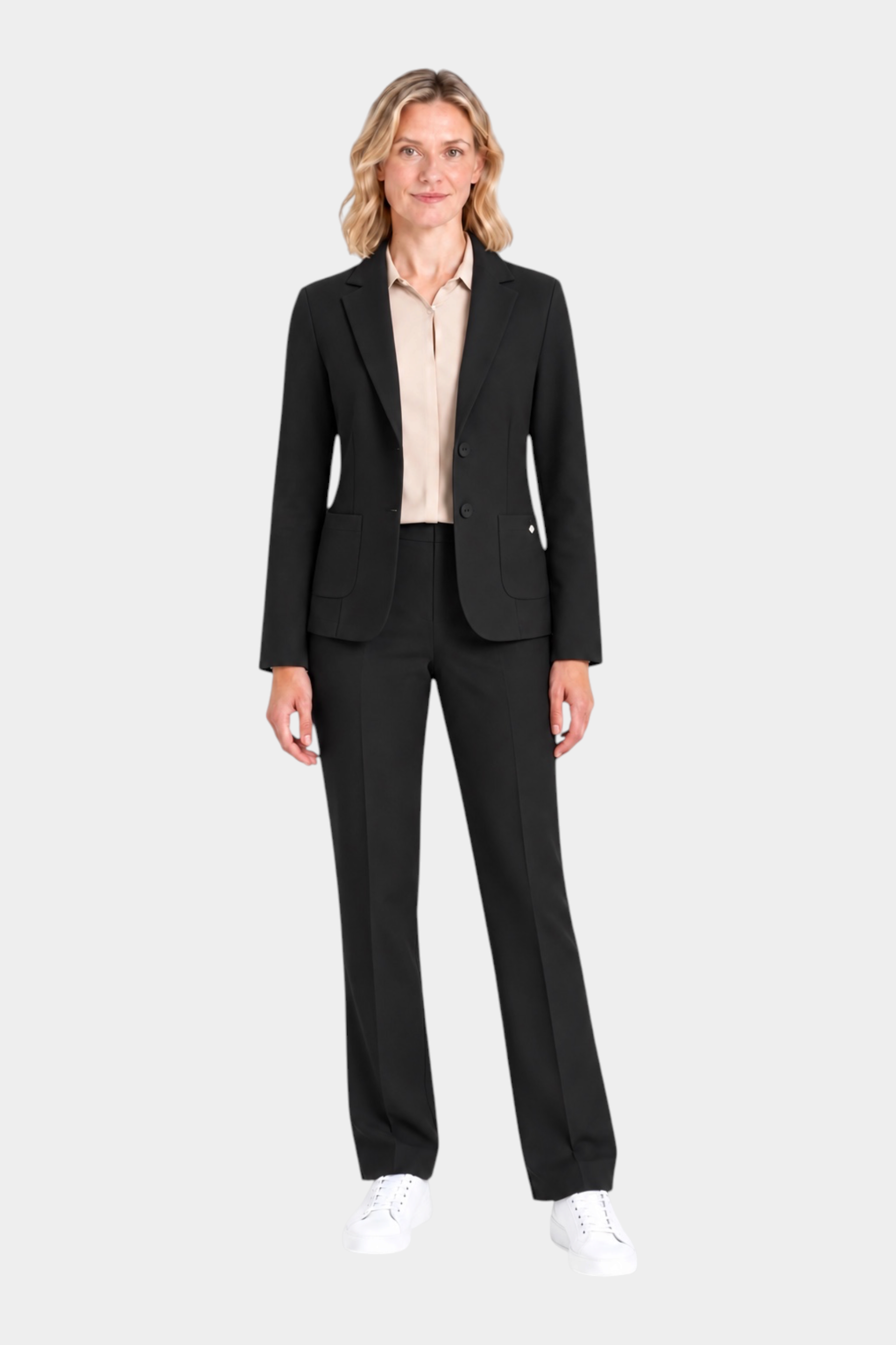 Modella indossa blazer nero a due bottoni RAGNO con camicia beige e pantaloni coordinati, stile Follower SRL