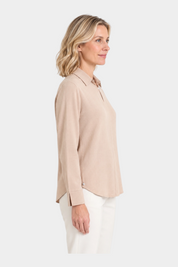 Modella di profilo indossa una blusa Follower SRL in flanella leggera color beige con scollo a serafino e colletto