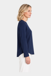 Modella di profilo indossa blusa girocollo blu in Light Flannel di Follower SRL con maniche lunghe e orlo curvo
