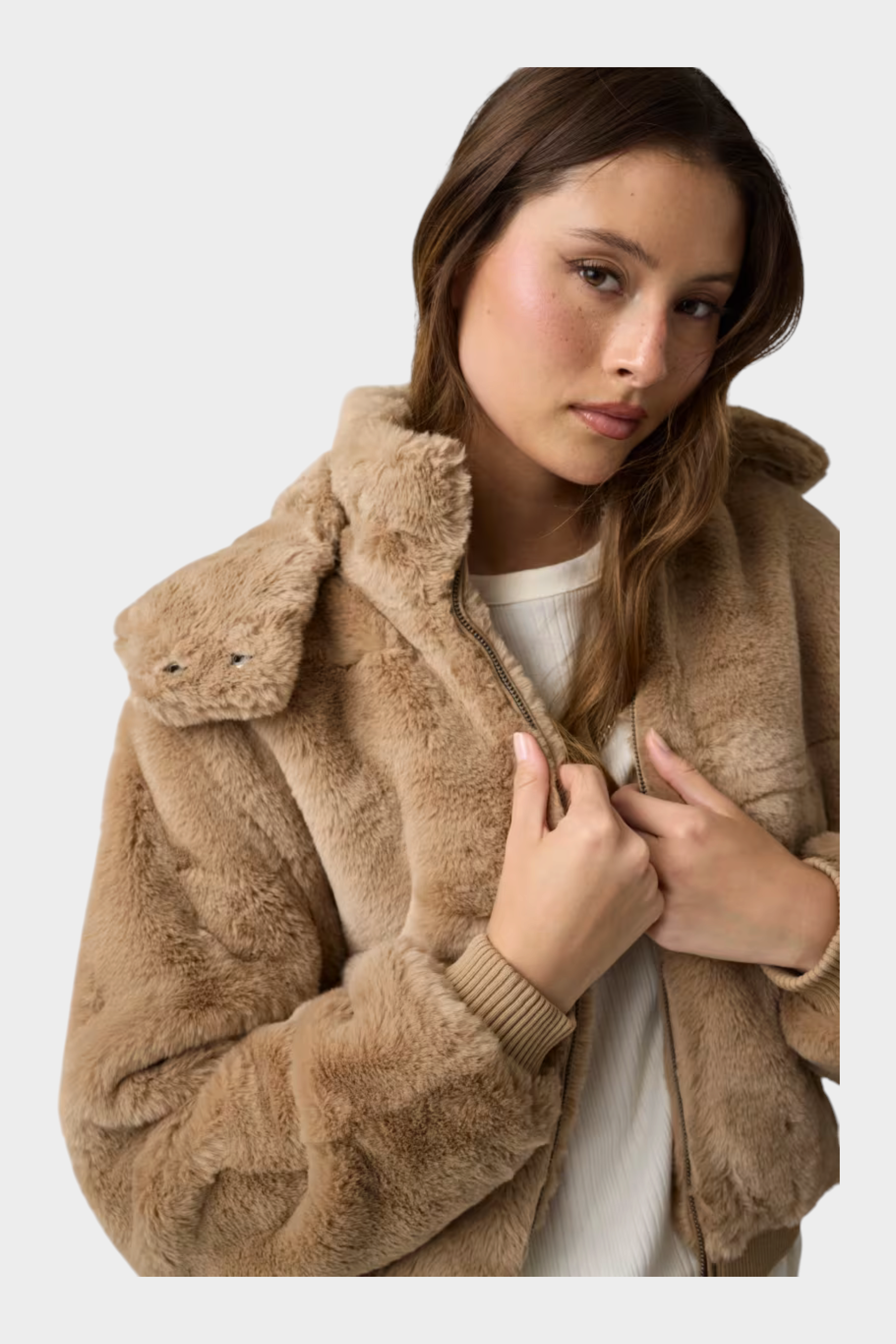 Modella indossa un bomber beige in pelliccia sintetica con cappuccio e polsini a coste, collezione Follower SRL