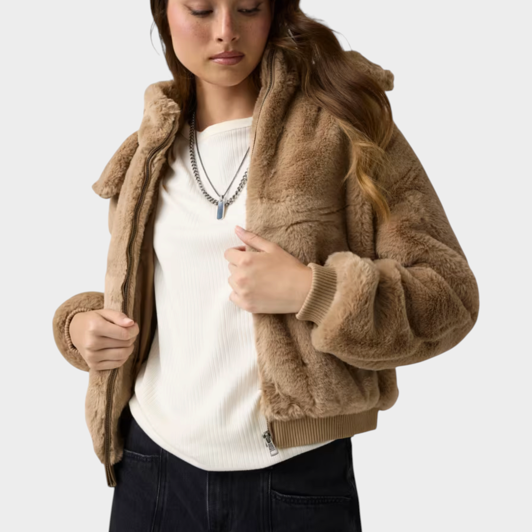 Modella indossa un bomber beige in pelliccia sintetica con cappuccio di Follower SRL, abbinato a maglia bianca