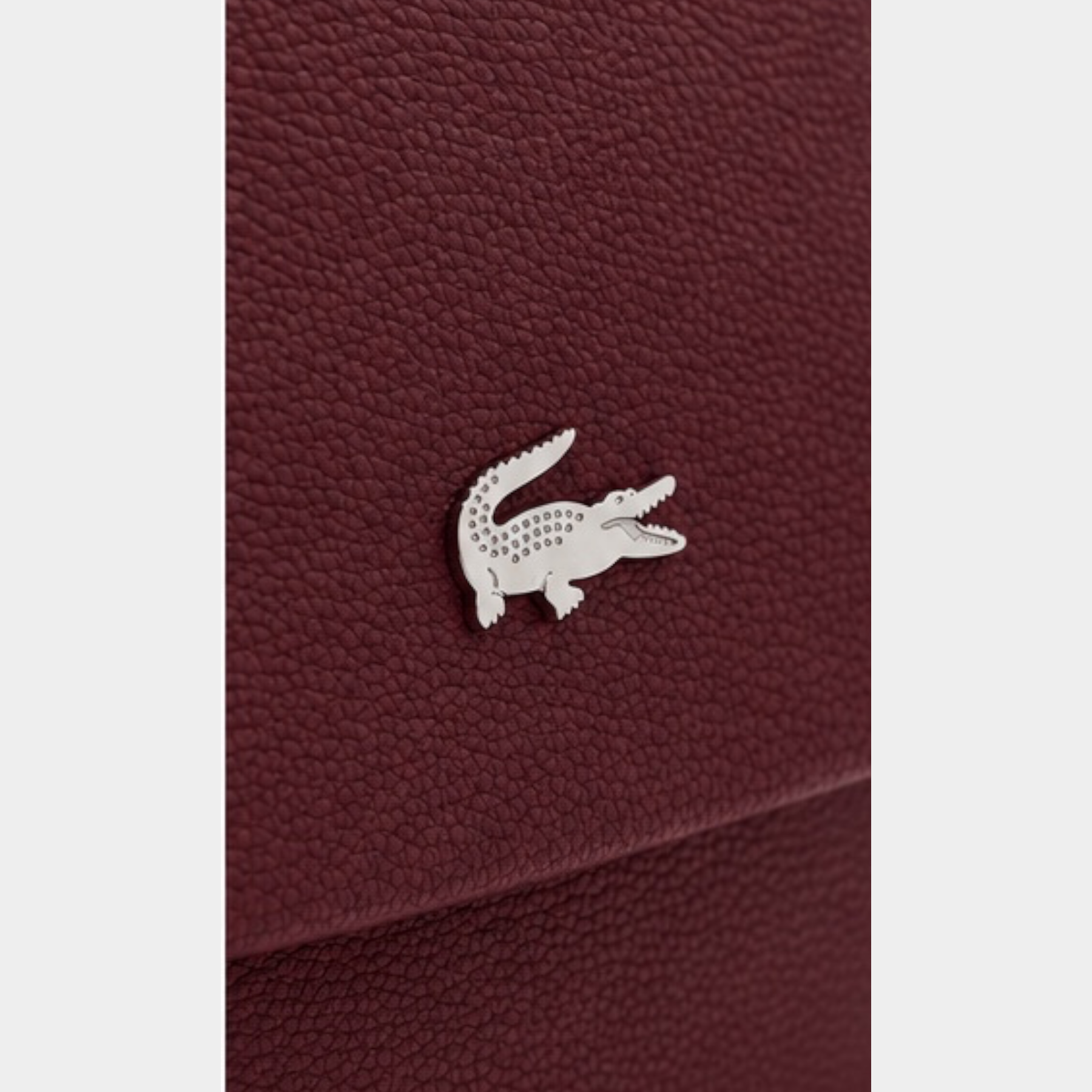Dettaglio della borsa a tracolla Follower SRL Lacoste color bordeaux con logo coccodrillo argentato su pelle martellata