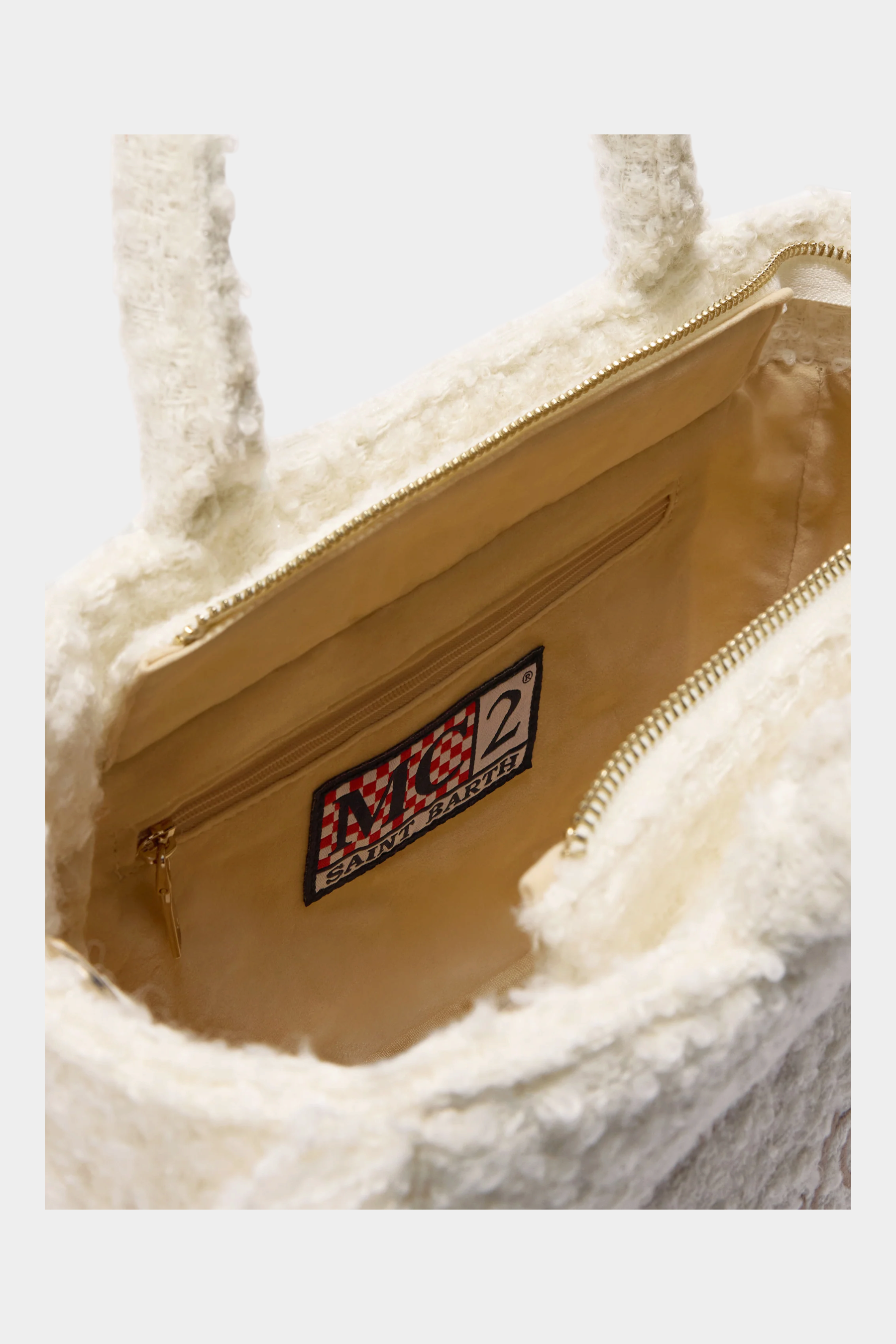 Interno della borsa Follower SRL Colette in tessuto bouclé bianco con etichetta logo MC2 SAINT BARTH e zip