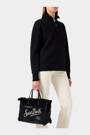 Borsa Follower SRL Colette nera in velluto con ricamo logo bianco e dettagli sfrangiati tenuta da una modella