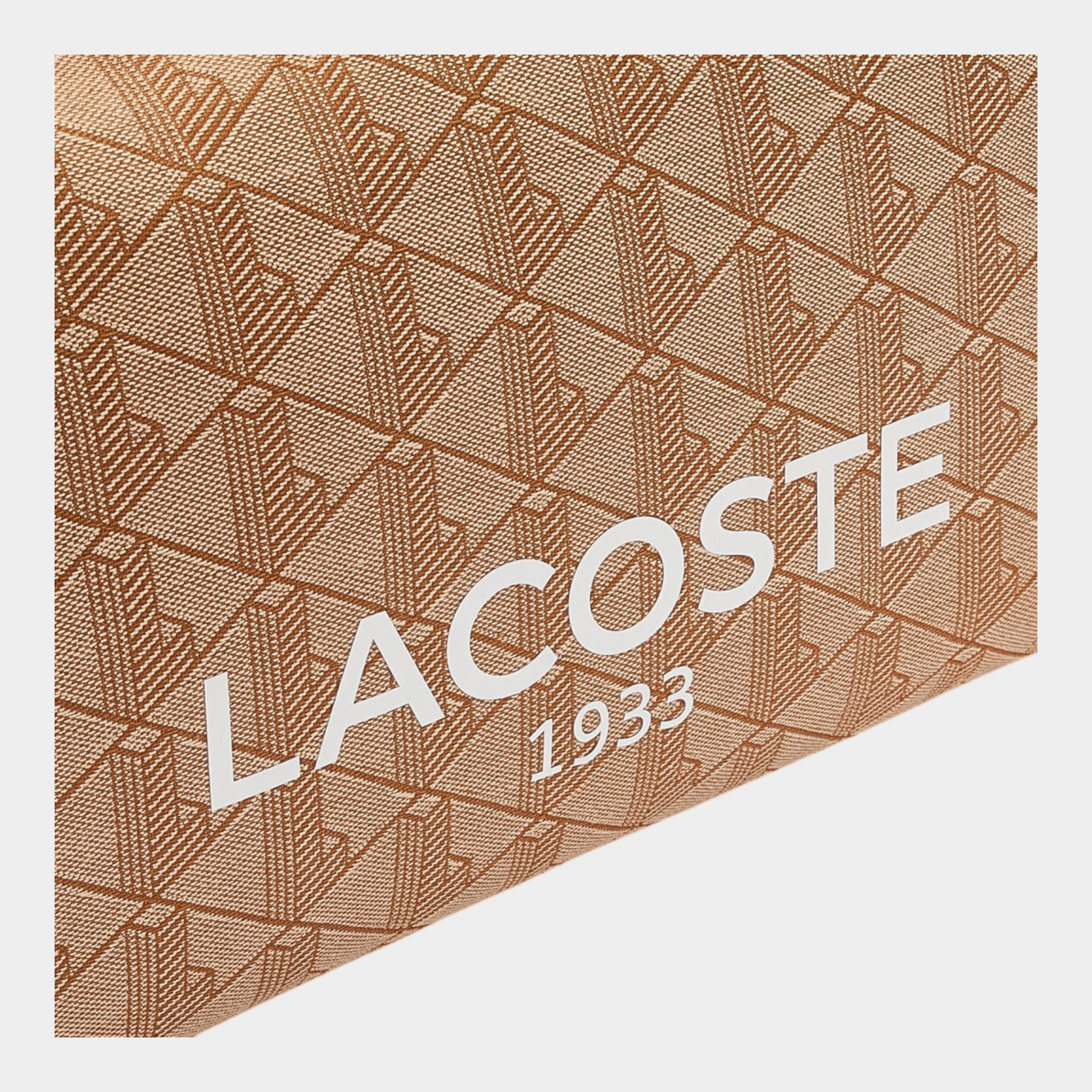 Dettaglio del tessuto jacquard beige con stampa Heritage e logo bianco Lacoste 1933 della borsa Follower SRL