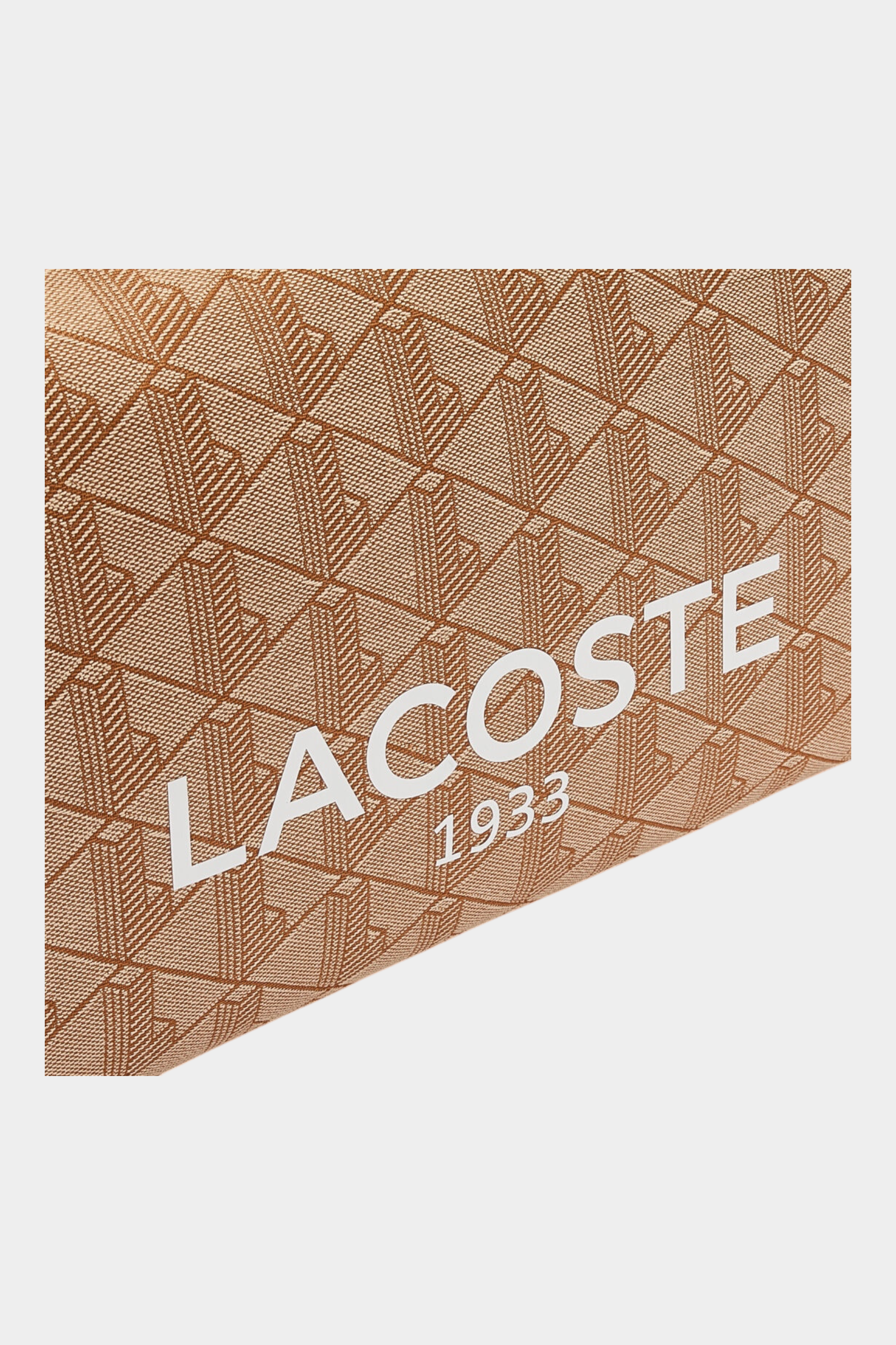 Dettaglio del tessuto jacquard beige con stampa Heritage e logo bianco Lacoste 1933 della borsa Follower SRL