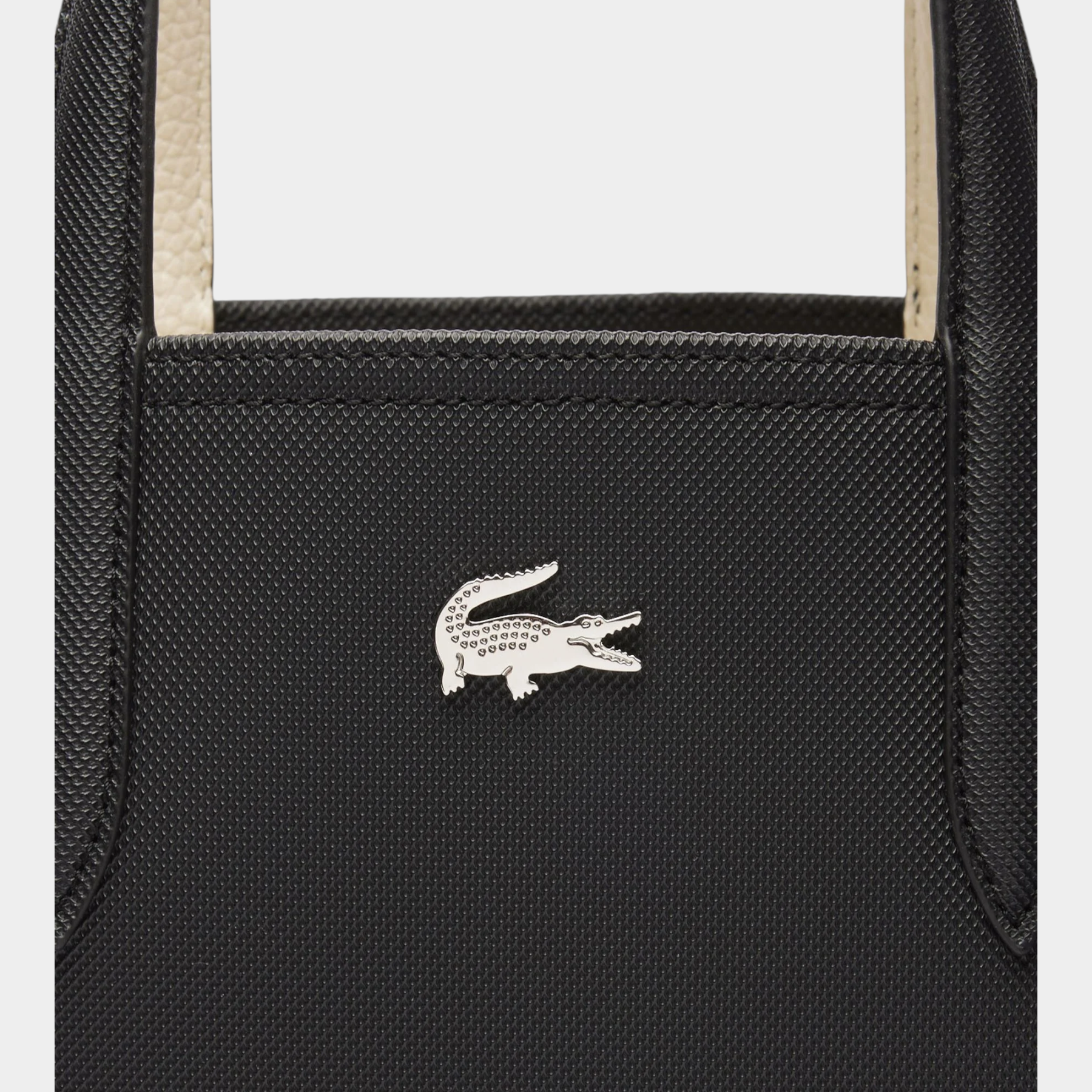 Dettaglio del logo coccodrillo argentato su borsa da viaggio reversibile nera Follower SRL Lacoste