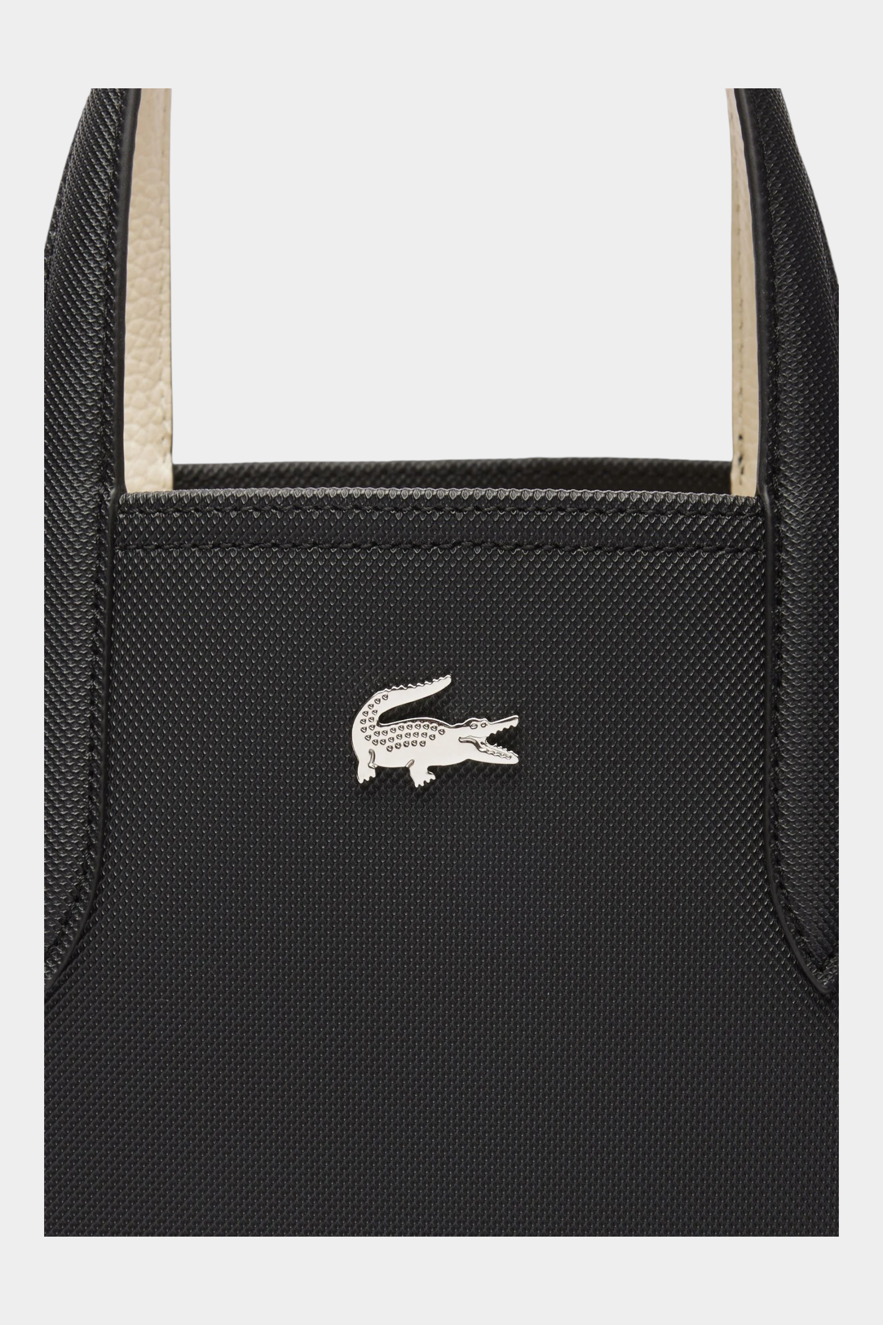 Dettaglio del logo coccodrillo argentato su borsa da viaggio reversibile nera Follower SRL Lacoste
