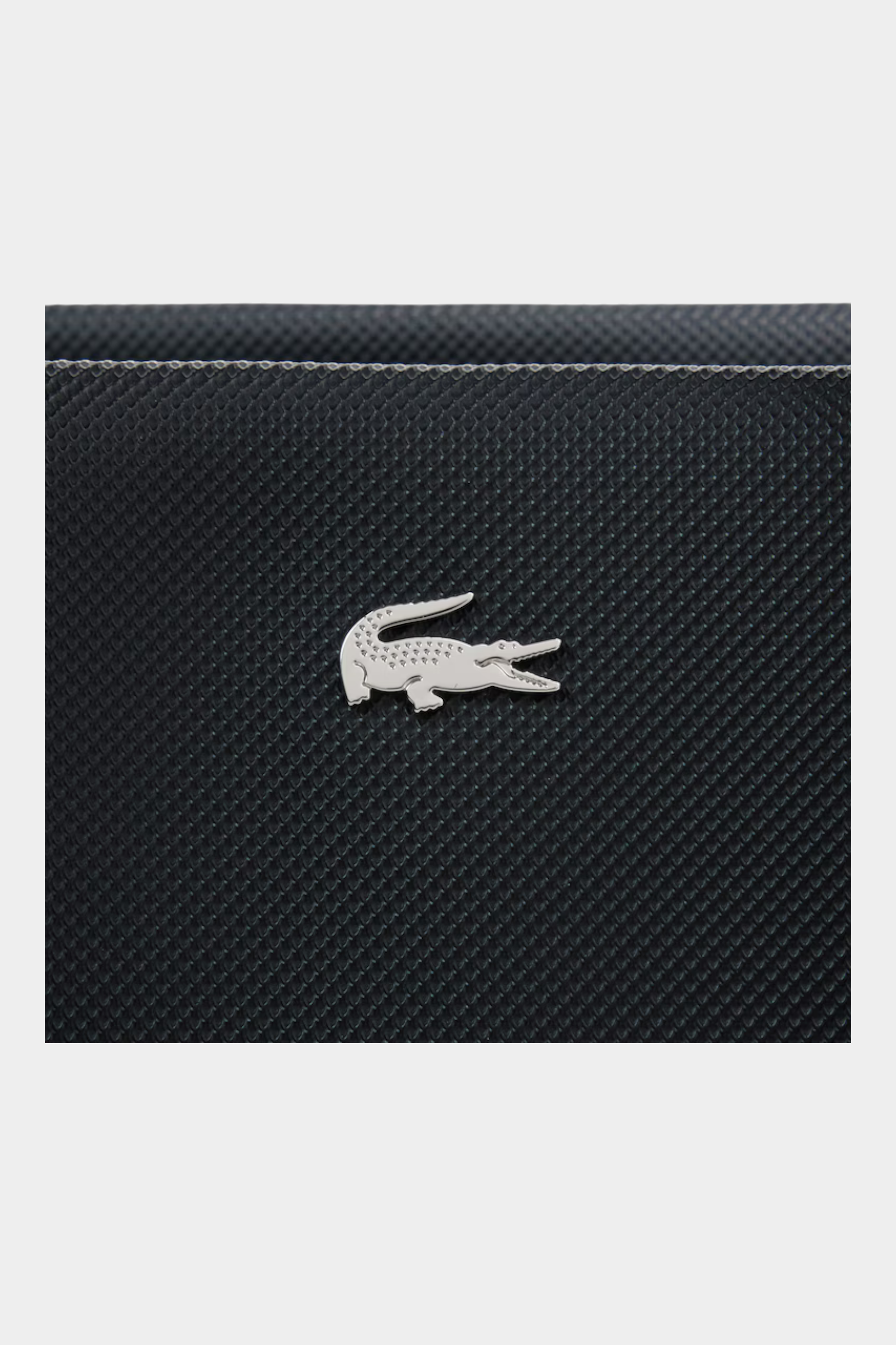 Dettaglio del logo coccodrillo argentato su borsa nera testurizzata Follower SRL