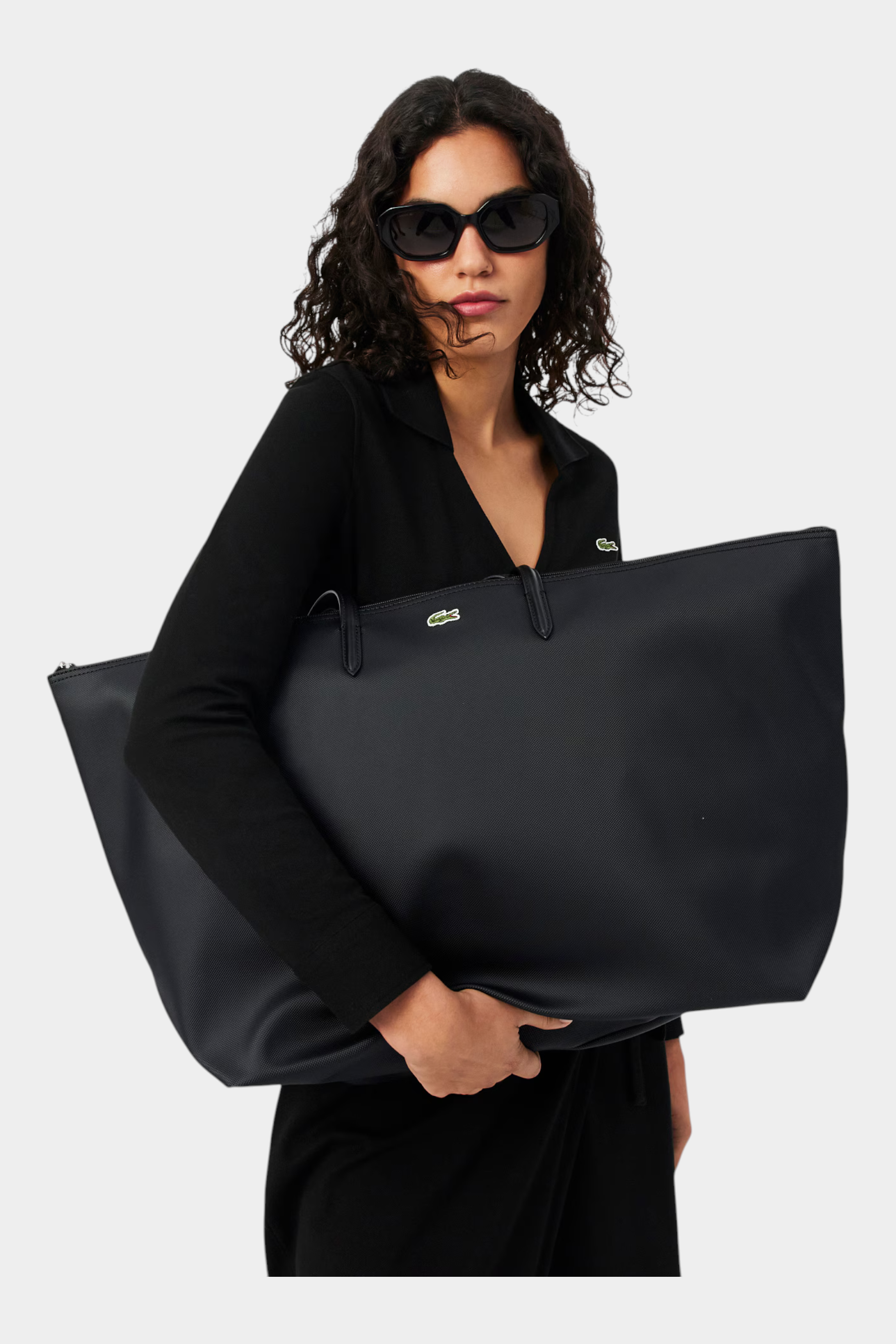 Modella indossa una borsa shopping XXL nera Lacoste L.12.12 Concept di Follower SRL con logo a coccodrillo