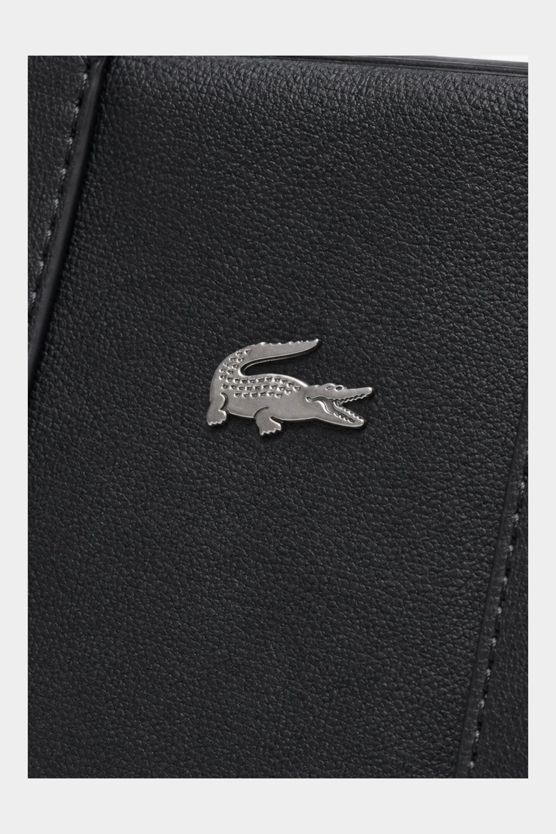 Dettaglio del logo coccodrillo metallico su borsa tote nera in materiale sintetico granulato Follower SRL