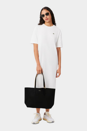 Modella indossa abito bianco con borsa tote nera Follower SRL reversibile con pochette inclusa