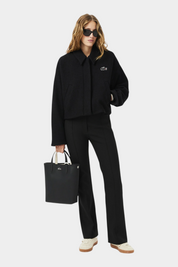 Modella con borsa da viaggio verticale reversibile nera Follower SRL, indossata con giacca e pantaloni neri