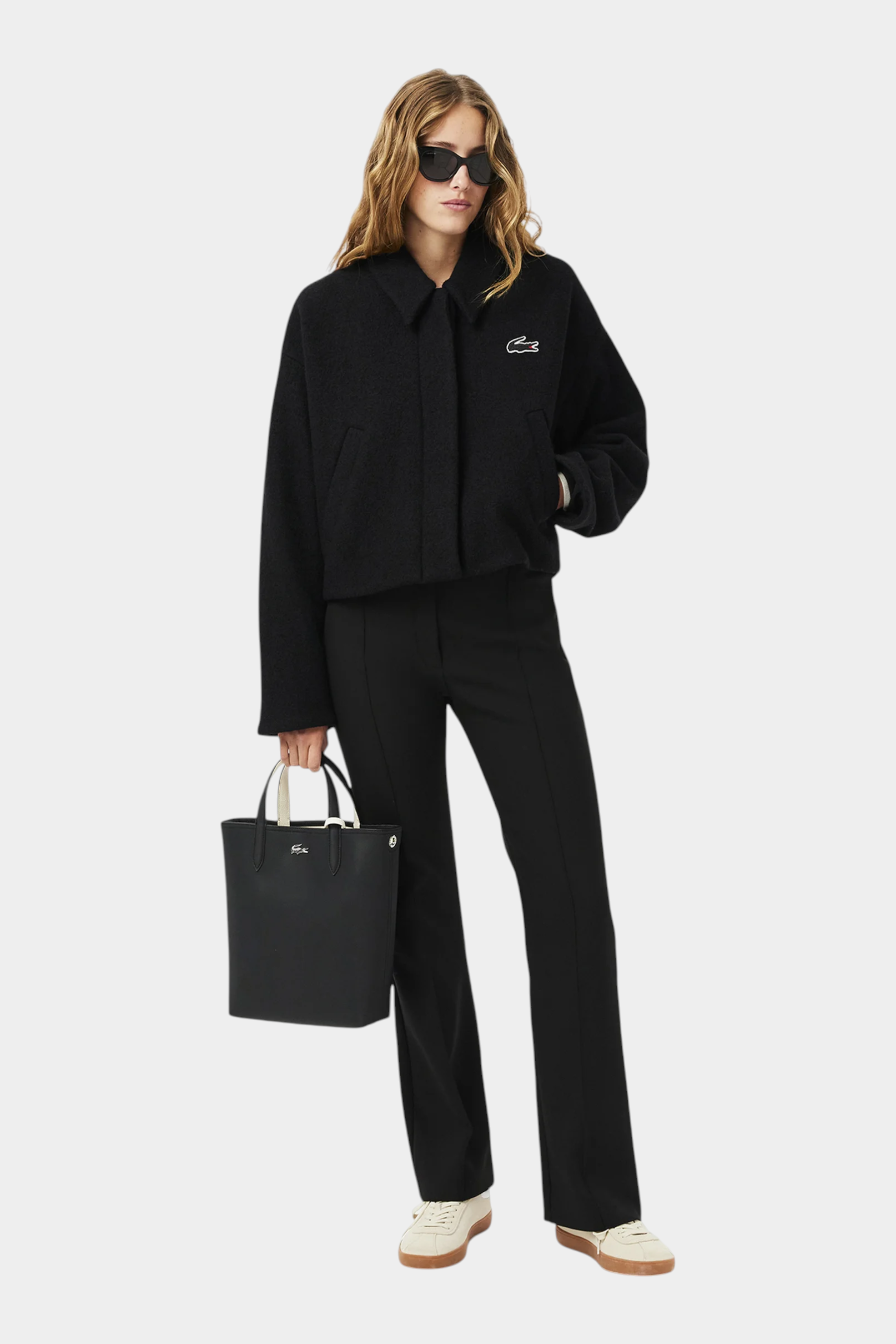 Modella con borsa da viaggio verticale reversibile nera Follower SRL, indossata con giacca e pantaloni neri