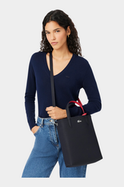 Modella indossa borsa da viaggio verticale reversibile blu Follower SRL con manici rossi a contrasto