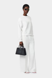 Modella indossa un completo bianco con la borsa nera Daily City di Follower SRL, vista frontale
