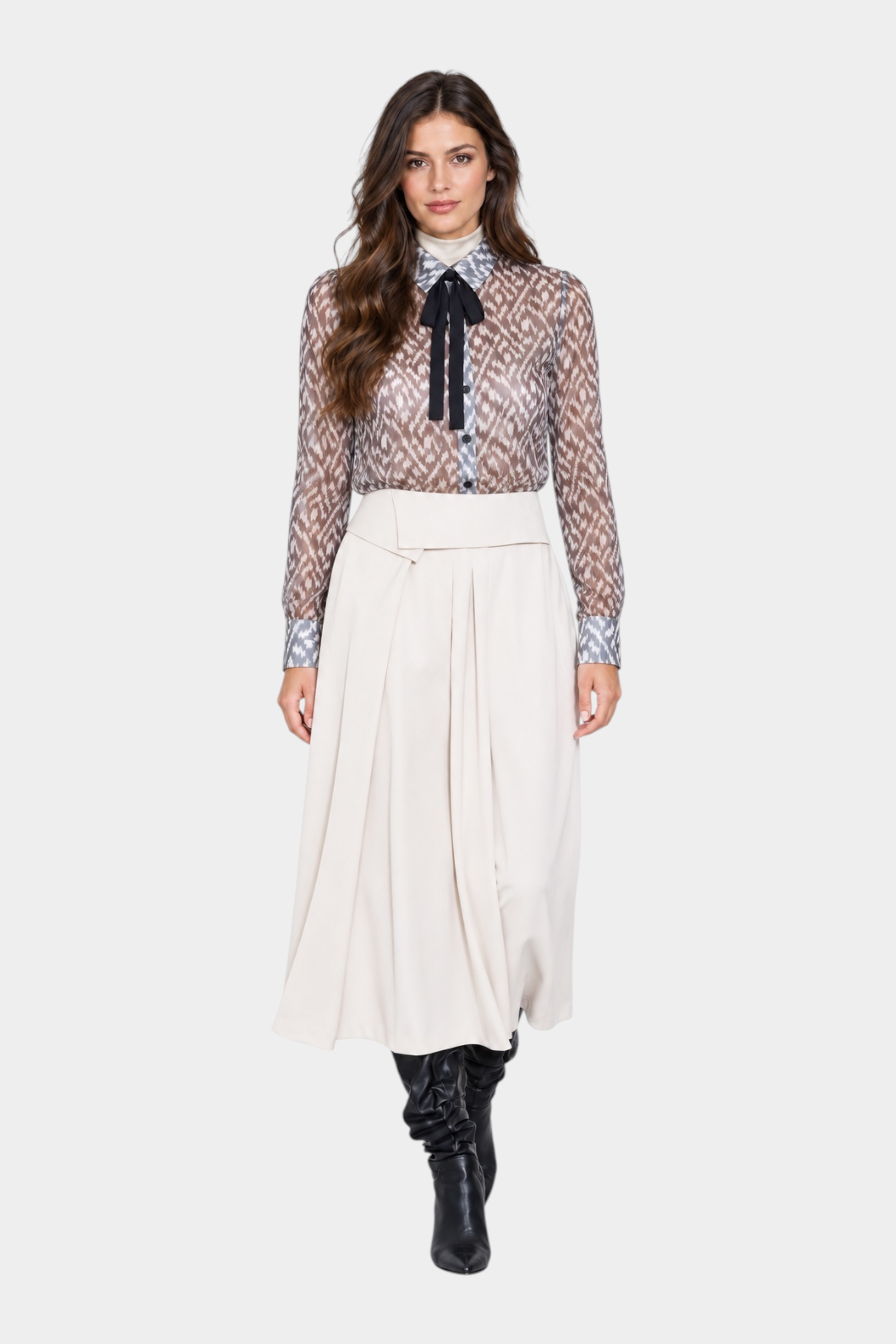 Modella indossa camicia luxury Follower SRL nera trasparente con stampa geometrica e fiocco al collo su gonna midi