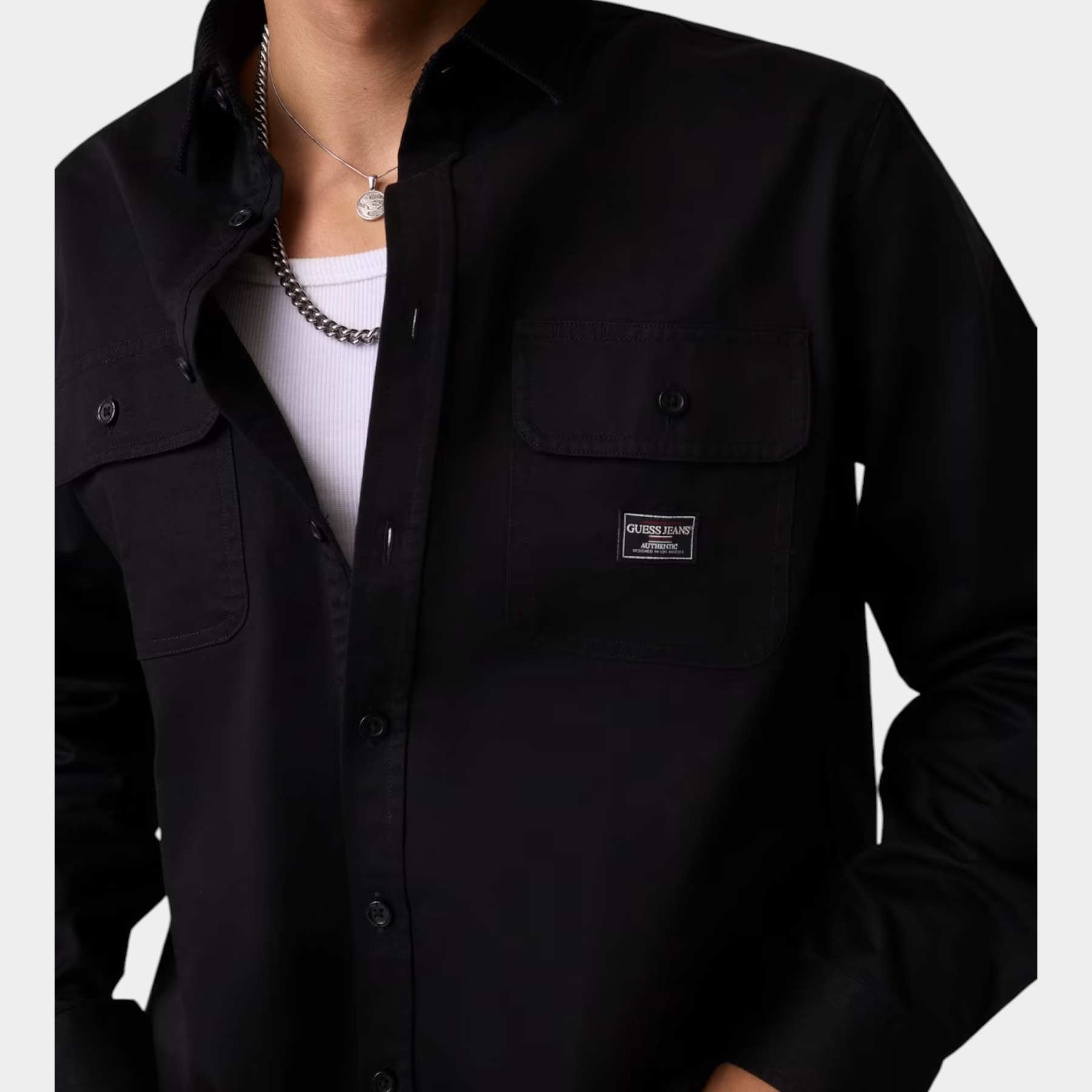 Camicia nera regular-fit GUESS indossata da un modello, con tasche frontali e logo Follower SRL
