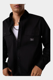 Camicia nera regular-fit GUESS indossata da un modello, con tasche frontali e logo Follower SRL