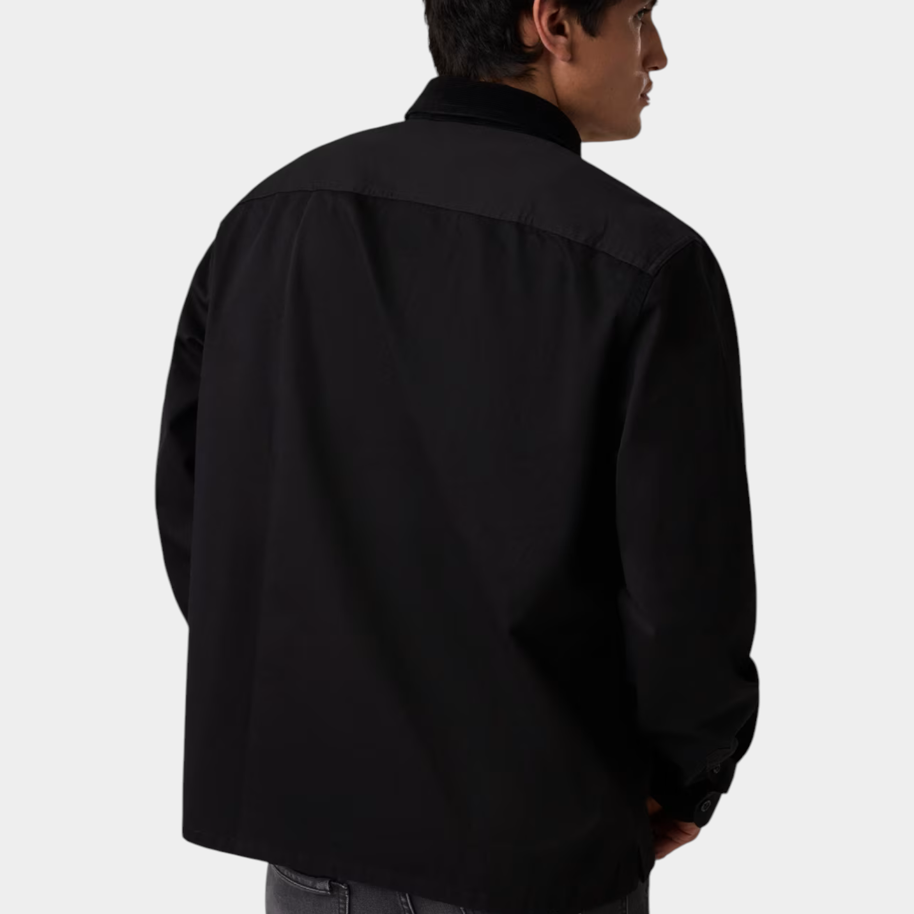 Vista posteriore di un uomo che indossa una camicia nera regular-fit GUESS di Follower SRL con jeans grigi