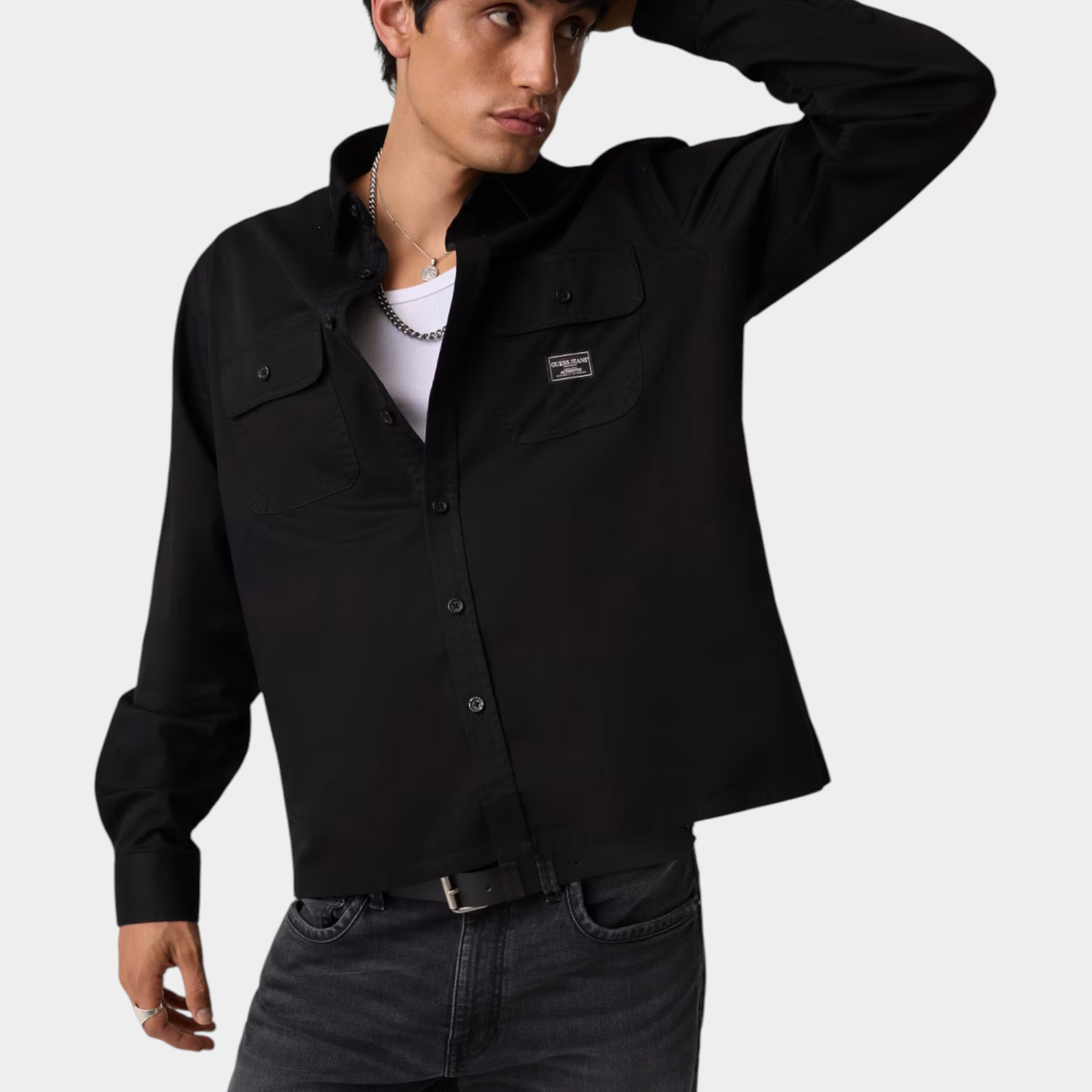 Modello indossa camicia nera regular-fit GUESS con tasche frontali, proposta da Follower SRL su sfondo neutro