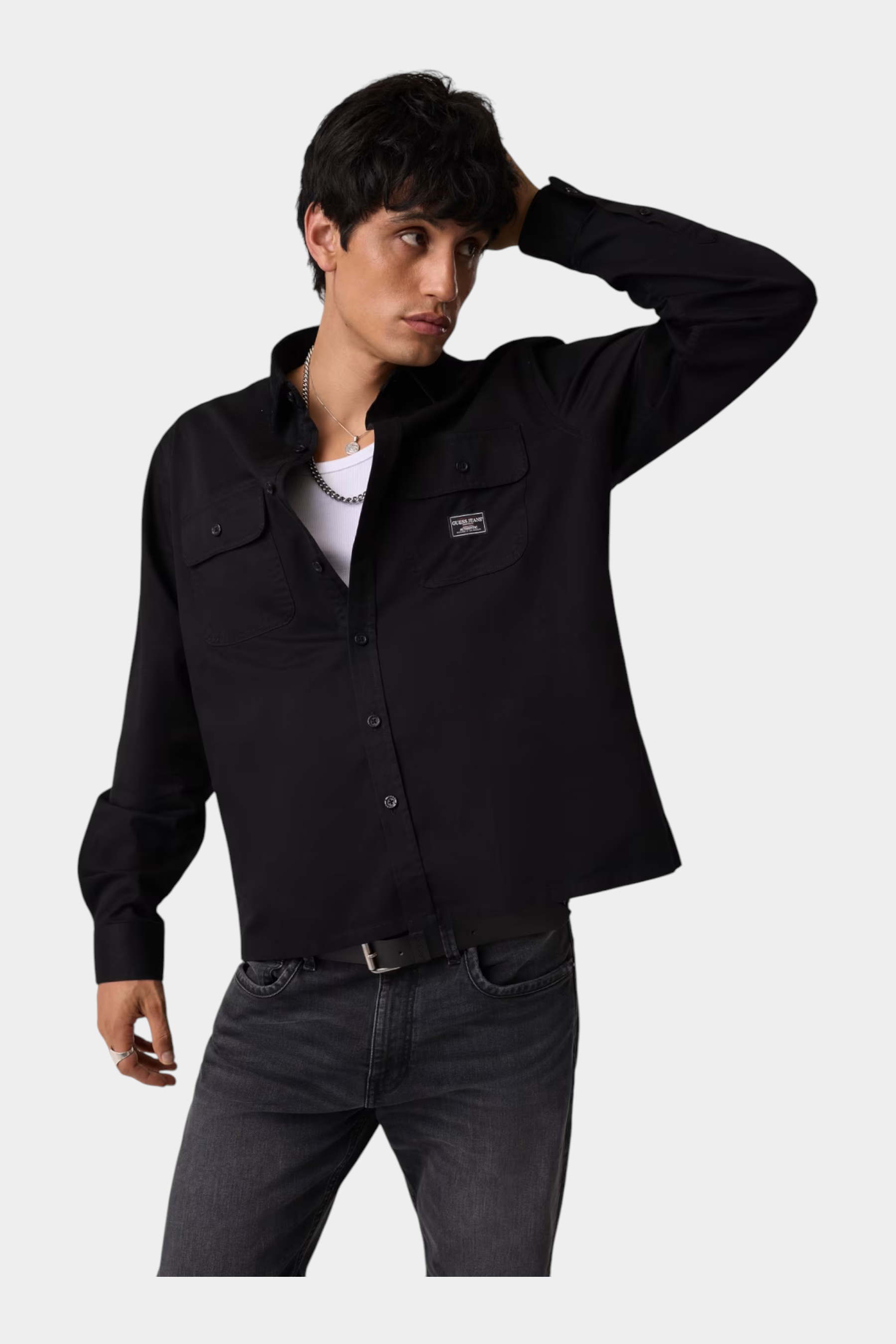 Modello indossa camicia nera regular-fit GUESS con tasche frontali, proposta da Follower SRL su sfondo neutro