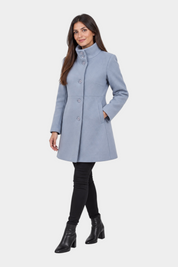 Modella indossa un cappotto iconico Follower SRL azzurro con collo alto e chiusura a bottoni su sfondo neutro