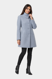 Modella indossa un cappotto iconico Follower SRL azzurro con collo alto e chiusura a bottoni su sfondo grigio