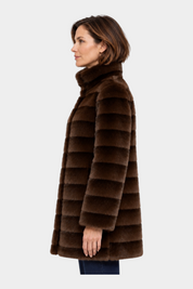 Modella indossa cappotto lungo reversibile marrone in ecopelliccia Follower SRL con colletto alto, vista laterale