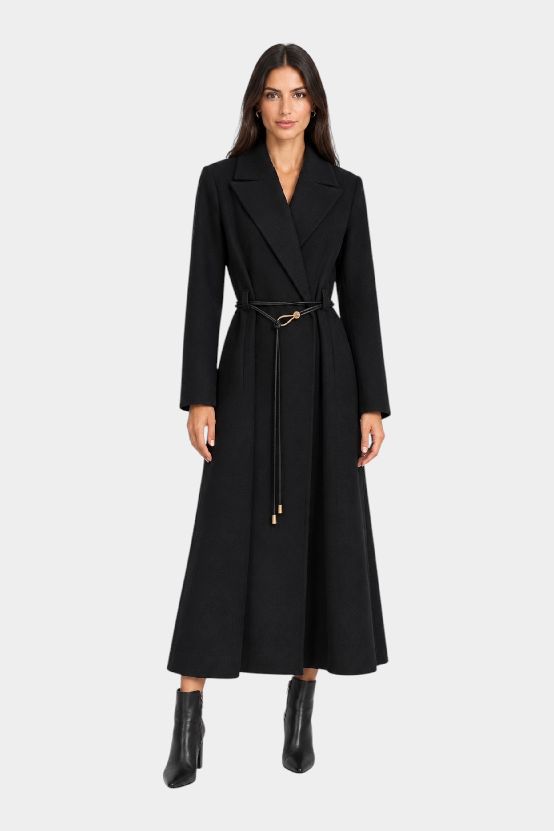 Modella indossa un cappotto lungo nero Follower SRL con cintura sottile in vita e stivaletti coordinati