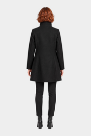 Vista posteriore di un cappotto iconico nero Follower SRL indossato da una modella con capelli rossi