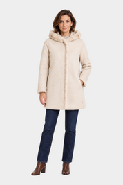 Modella indossa cappotto lungo reversibile beige con cappuccio e finiture in pelliccia sintetica Follower SRL