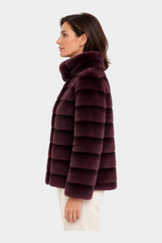 Modella indossa un cappotto reversibile bordeaux RAGNO di Follower SRL con collo alto e texture a fasce orizzontali