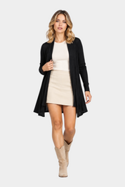 Modella indossa un cardigan spolverino nero Follower SRL aperto su top beige e minigonna, stile elegante e casual