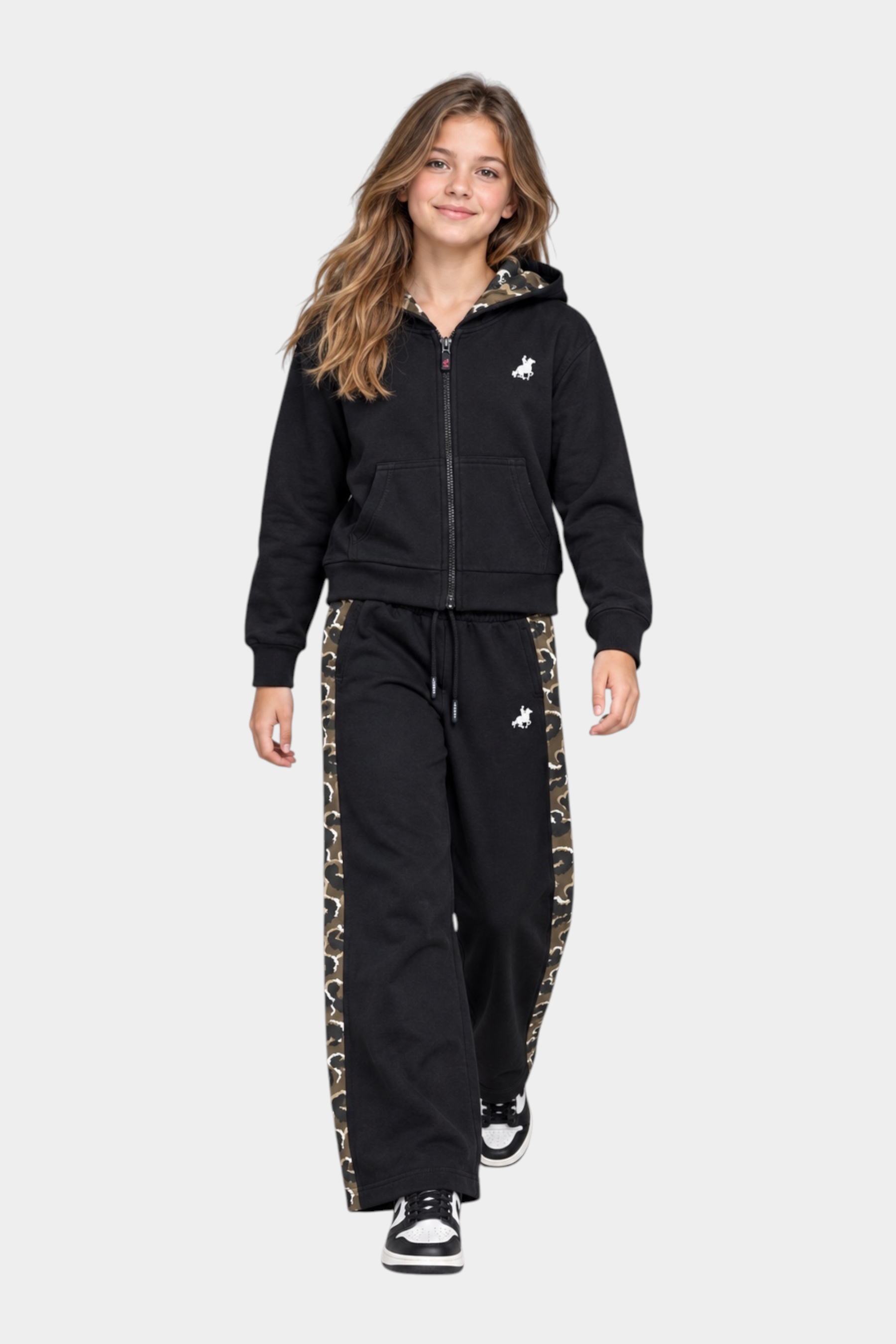 Ragazza indossa completo Follower SRL nero con felpa con cappuccio e pantaloni sportivi a fantasia mimetica